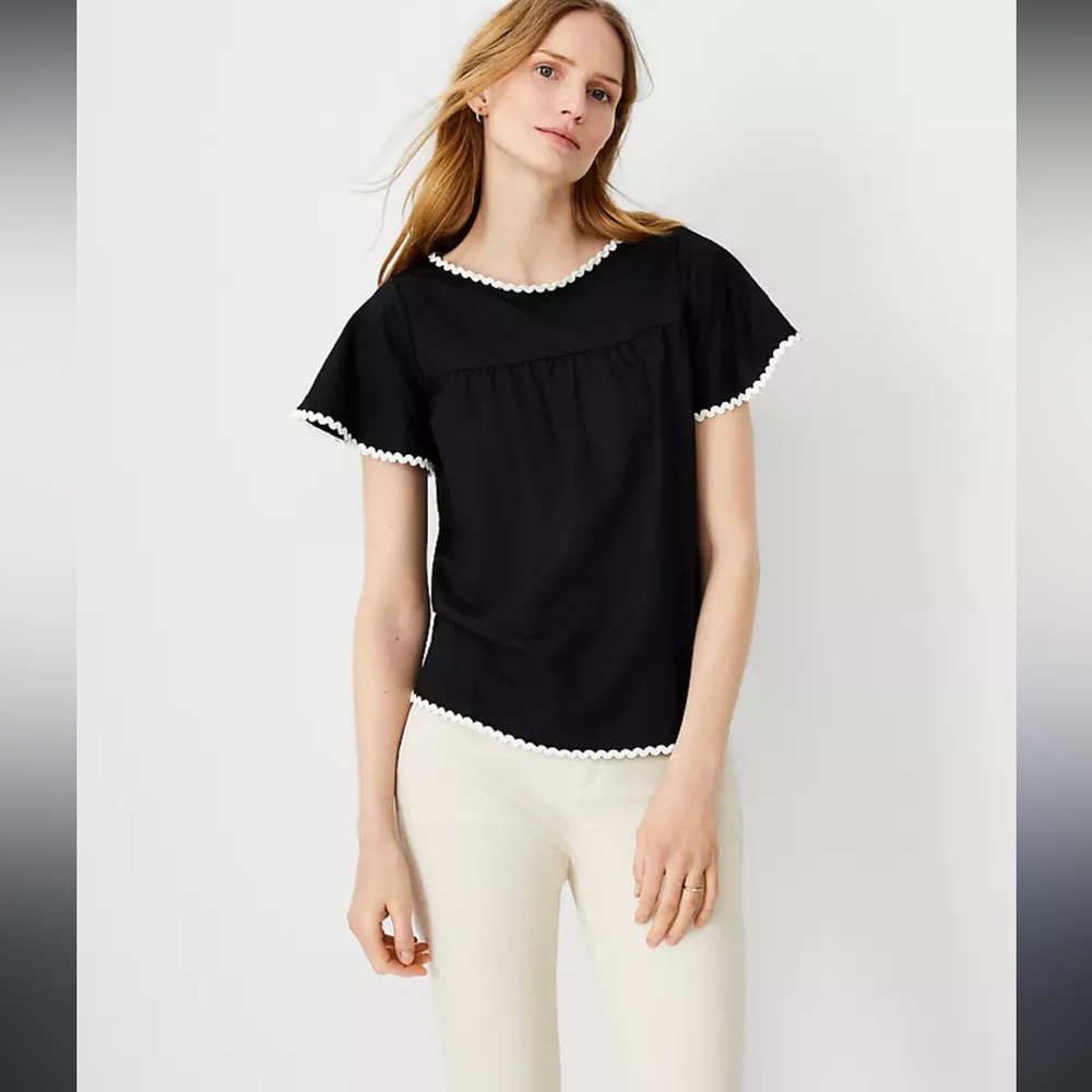 Black flutter sleeve top with white rickrack trim.